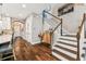Hallway view showcasing wood floors, white trim, and staircase leading to the upper level at 6022 S Elkins Ave, Tampa, FL 33611