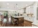 Open kitchen with white cabinets, granite counters, a large island, and stainless steel appliances at 6022 S Elkins Ave, Tampa, FL 33611