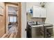 Laundry room featuring gray washer and dryer, shelving and is conveniently located off the main living area at 6022 S Elkins Ave, Tampa, FL 33611