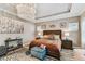 Main bedroom with modern chandelier, wooden floors, a bed with colorful pillows and bright, airy windows at 6022 S Elkins Ave, Tampa, FL 33611