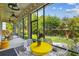 Enclosed patio offers bright furniture, ceiling fans, and lush backyard views at 6022 S Elkins Ave, Tampa, FL 33611