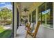 Inviting enclosed patio with ceiling fan, rocking chairs, and views of the lush yard at 6022 S Elkins Ave, Tampa, FL 33611