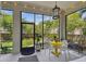 Enclosed patio with bright yellow table and stylish seating surrounded by greenery at 6022 S Elkins Ave, Tampa, FL 33611
