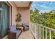 Balcony seating area with chairs, small table and leafy green privacy hedge at 620 Bayway Blvd # 1, Clearwater, FL 33767