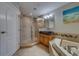 Elegant bathroom featuring walk-in shower, separate tub, unique bowl sink, and natural wood cabinet at 620 Bayway Blvd # 1, Clearwater, FL 33767