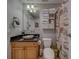 Bathroom featuring a black speckled countertop, wood cabinets, and a seashell-themed shower curtain at 620 Bayway Blvd # 1, Clearwater, FL 33767