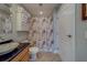 Bright bathroom with tile floors, stacked white towels, and seashell-themed shower curtain at 620 Bayway Blvd # 1, Clearwater, FL 33767