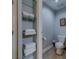 Cozy bathroom featuring a toilet and organized towel storage with glass shelving at 620 Bayway Blvd # 1, Clearwater, FL 33767