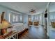 Spacious bedroom with two armchairs, three windows, wood floors, and ample closet space at 620 Bayway Blvd # 1, Clearwater, FL 33767