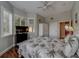 Bedroom with hardwood floors, a ceiling fan, a TV, and a large bed with floral pattern at 620 Bayway Blvd # 1, Clearwater, FL 33767