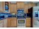 Detailed view of the kitchen's stainless steel appliances, granite countertops, wood cabinets, and tile backsplash at 620 Bayway Blvd # 1, Clearwater, FL 33767