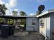 Side of gray house with covered area, trash cans, and satellite dishes on the roof at 6206 Paul Buchman Hwy, Plant City, FL 33565
