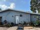 Gray house exterior featuring a small front garden area with various potted plants and a wreath on the front door at 6206 Paul Buchman Hwy, Plant City, FL 33565