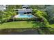 Aerial view of community pool with a pond, green space, palm trees, and covered seating area at 6304 Parkside Meadow Dr, Tampa, FL 33625