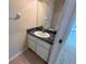 A half-bathroom with a black granite countertop and white cabinet at 6304 Parkside Meadow Dr, Tampa, FL 33625