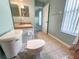 Standard bathroom featuring tile floors, toilet, sink, and a window for natural light at 6304 Parkside Meadow Dr, Tampa, FL 33625