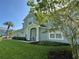 Stylish two-story home with a blue exterior, lush green lawn, and mature trees at 6304 Parkside Meadow Dr, Tampa, FL 33625