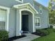 Inviting front entrance with a black door, manicured landscaping, and a home security system for added peace of mind at 6304 Parkside Meadow Dr, Tampa, FL 33625