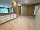 Kitchen seamlessly connects to the entry hall and living area, boasting white cabinets and tile floor at 6304 Parkside Meadow Dr, Tampa, FL 33625