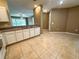 Kitchen with ample cabinet space and a view to living area. White appliances and tile flooring throughout at 6304 Parkside Meadow Dr, Tampa, FL 33625