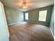 Spacious primary bedroom with two windows, ceiling fan, carpet flooring, and light blue walls at 6304 Parkside Meadow Dr, Tampa, FL 33625