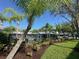 Community pool featuring palm trees, a black fence, lush landscaping and lounge chairs creating a resort-like ambiance at 6304 Parkside Meadow Dr, Tampa, FL 33625