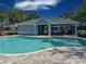 Community pool with blue water, covered seating area, and brick paver deck. Perfect for relaxing or entertaining guests at 6304 Parkside Meadow Dr, Tampa, FL 33625