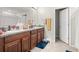 Bathroom with double sinks, granite countertops, and wood cabinets; featuring tiled floors and plenty of counter space at 6708 Hazelnut Spice Dr, Ruskin, FL 33573