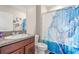 Bathroom featuring a vanity with granite countertop, modern sink and a toilet near a shower/tub with a blue curtain at 6708 Hazelnut Spice Dr, Ruskin, FL 33573