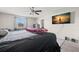 Bright bedroom features large screen television, ceiling fan, closet, and comfortable furniture; well-appointed room at 6708 Hazelnut Spice Dr, Ruskin, FL 33573