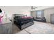 Spacious bedroom with a ceiling fan, large bed with dark comforter and additional seating area near bright windows at 6708 Hazelnut Spice Dr, Ruskin, FL 33573