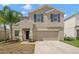 Two-story home featuring desert landscaping, a two car garage, and neutral stucco with dark shutters at 6708 Hazelnut Spice Dr, Ruskin, FL 33573