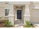 Inviting front door with stucco columns and landscaping. The door is dark blue at 6708 Hazelnut Spice Dr, Ruskin, FL 33573