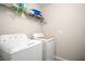 Laundry room featuring a GE washing machine and dryer with upper shelving for storage; practical and convenient at 6708 Hazelnut Spice Dr, Ruskin, FL 33573