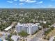 Elevated aerial view of a large condo building and the surrounding residential area with lush trees at 700 Beach Ne Dr # 803, St Petersburg, FL 33701