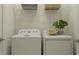 Practical laundry area with a white washer, dryer, and shelving for storage in a well-lit space at 7525 E 116Th St, Palmetto, FL 34221
