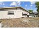 Exterior backyard view showing partial lawn with home in background at 8907 Pandora Ln, Port Richey, FL 34668