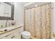 Cozy bathroom featuring a mosaic mirror, shower curtain, and classic fixtures at 8907 Pandora Ln, Port Richey, FL 34668