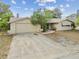 Charming single-story home featuring an attached garage, front yard landscaping, and a welcoming entryway at 8907 Pandora Ln, Port Richey, FL 34668