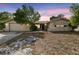Charming single-story home with a front lawn and attached two-car garage under a pink and blue sky at 8907 Pandora Ln, Port Richey, FL 34668