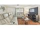 A living room featuring reclining furniture, hardwood floors, and a large television at 8907 Pandora Ln, Port Richey, FL 34668