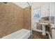 Bathroom featuring a shower-tub combo, pedestal sink, and a window for natural light at 906 E Broad St, Tampa, FL 33604