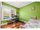Bright bedroom with vibrant green walls, hardwood floors, and a built-in desk at 906 E Broad St, Tampa, FL 33604