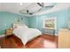 Calm bedroom features hardwood floors, blue walls, and a large window for plenty of natural light at 906 E Broad St, Tampa, FL 33604