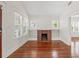 Living room with a brick fireplace, built-in shelving, hardwood floors, and natural light at 906 E Broad St, Tampa, FL 33604