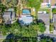 Aerial view of homes shows an in-ground screened pool and fenced yard within a neighborhood at 9410 Alanbrooke St, Temple Terrace, FL 33637