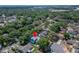 An aerial view of a neighborhood showcases a home with a private, fenced backyard surrounded by mature trees at 9410 Alanbrooke St, Temple Terrace, FL 33637