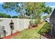 Beautifully landscaped backyard featuring a white fence, lush greenery, and decorative plants at 9410 Alanbrooke St, Temple Terrace, FL 33637