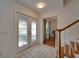 Bright foyer with tile flooring, glass doors, and a staircase with wooden railing at 9410 Alanbrooke St, Temple Terrace, FL 33637