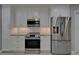 Kitchen features white cabinets, stainless steel appliances, granite countertops, and tile backsplash at 9410 Alanbrooke St, Temple Terrace, FL 33637